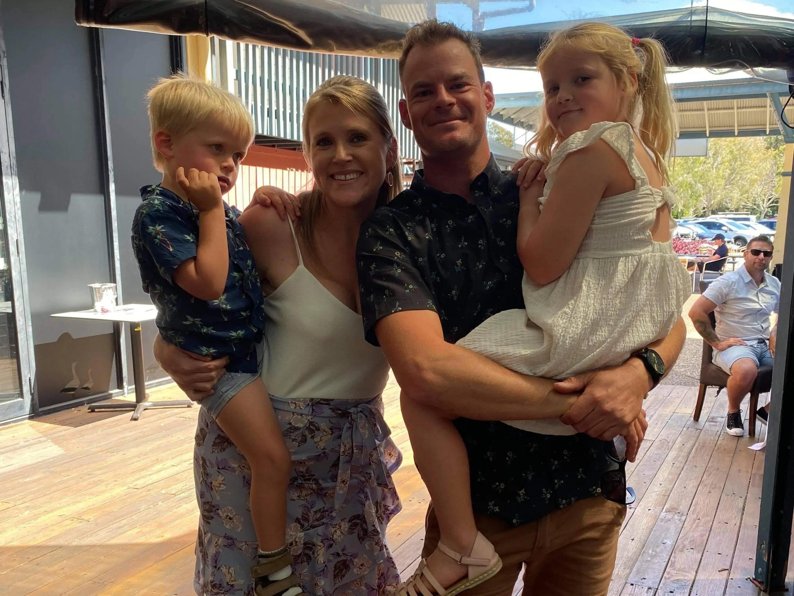 A family living with STXBP1 smiling together outdoors.